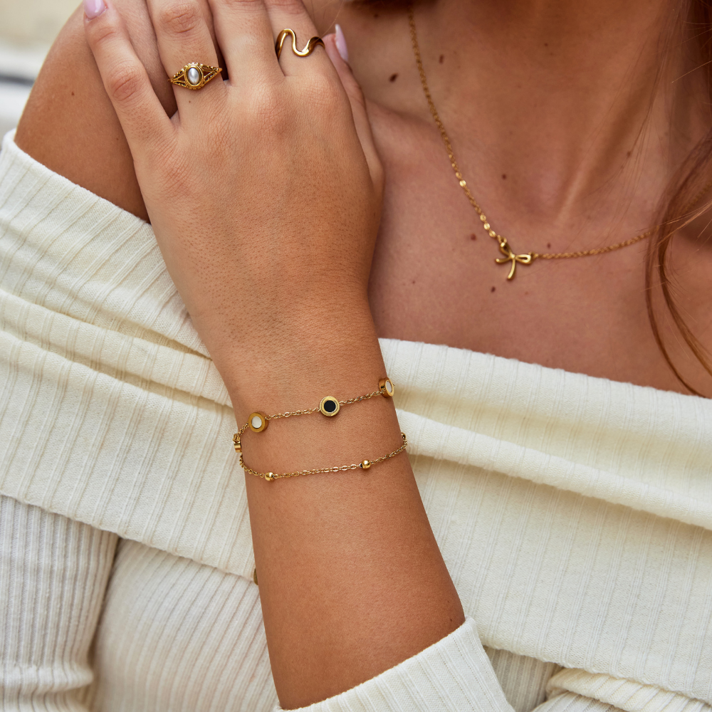 Carla – Brățară moale aurie cu elemente rotunde contrastante.