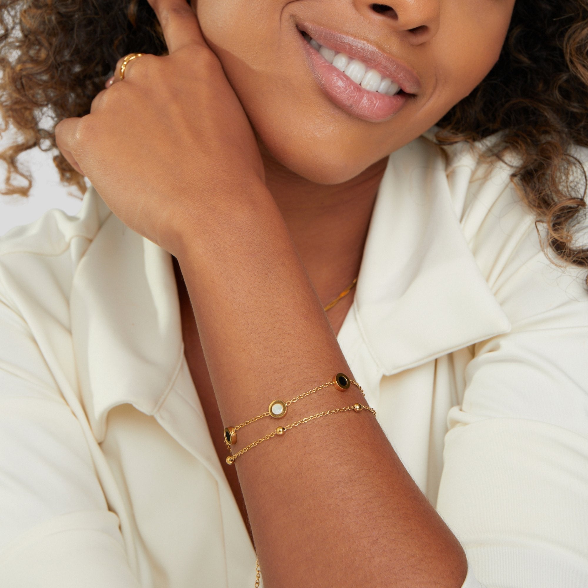 Carla – Brățară moale aurie cu elemente rotunde contrastante.